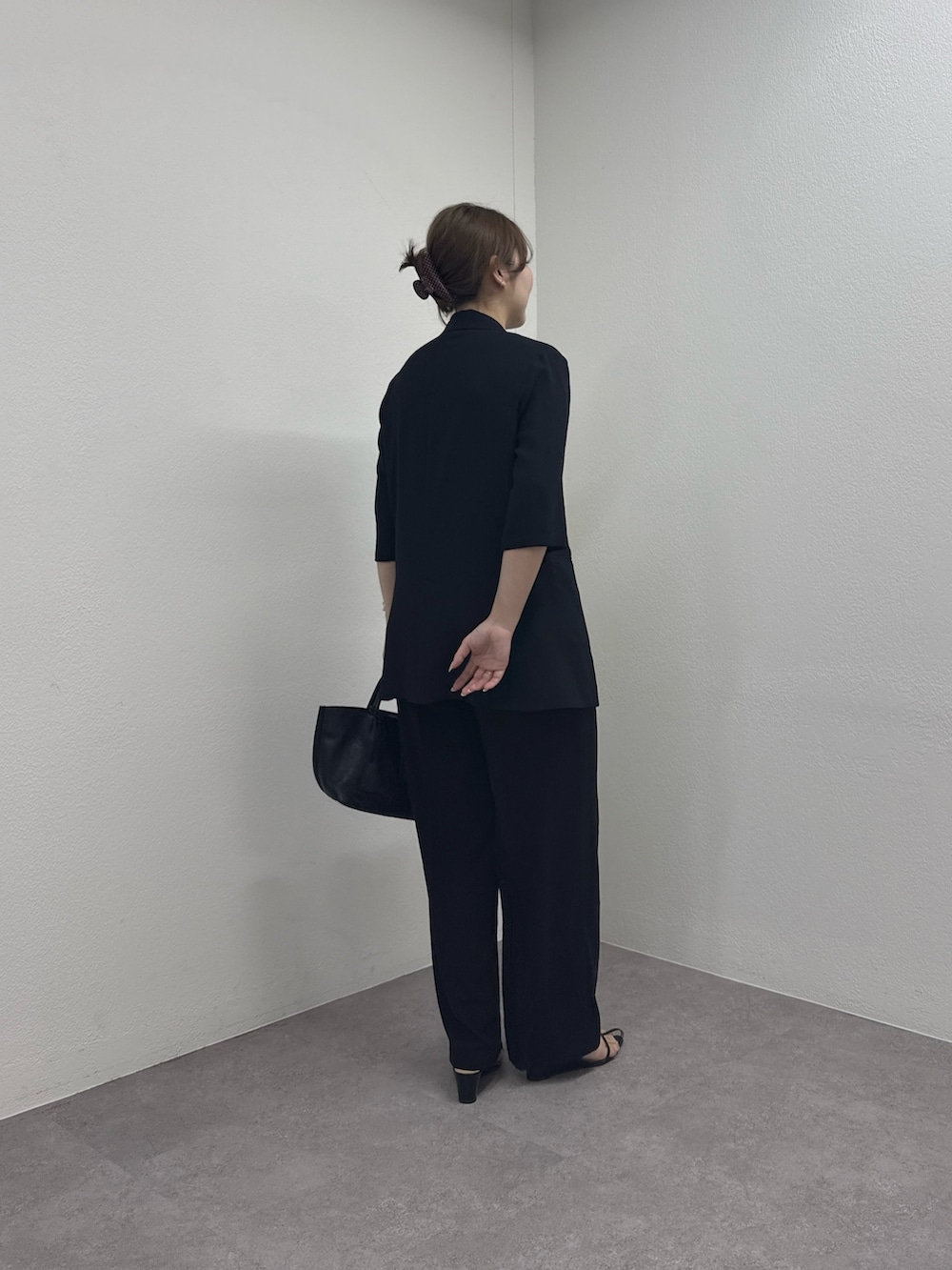ブラック系のテーラードジャケット、ブラック系のトートバッグ、ホワイト系のシャツ/ブラウスを着用したレディースの春コーディネートの3枚目の写真