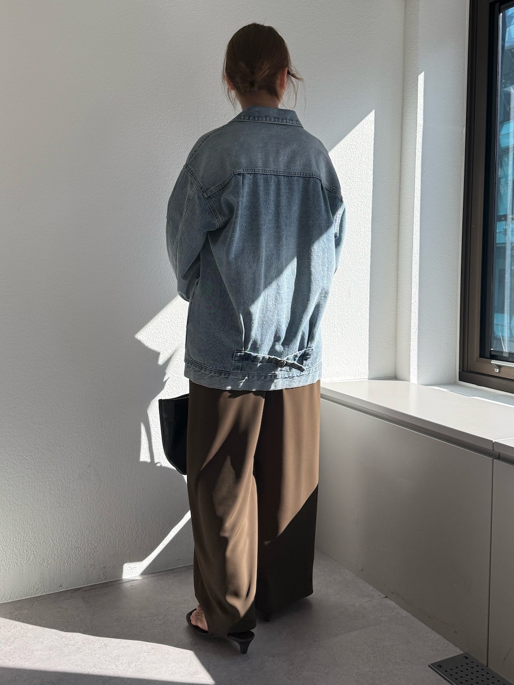 ブラウン系のその他パンツ、ブラック系のトートバッグ、ブルー系のベストを着用したレディースの冬コーディネートの2枚目の写真