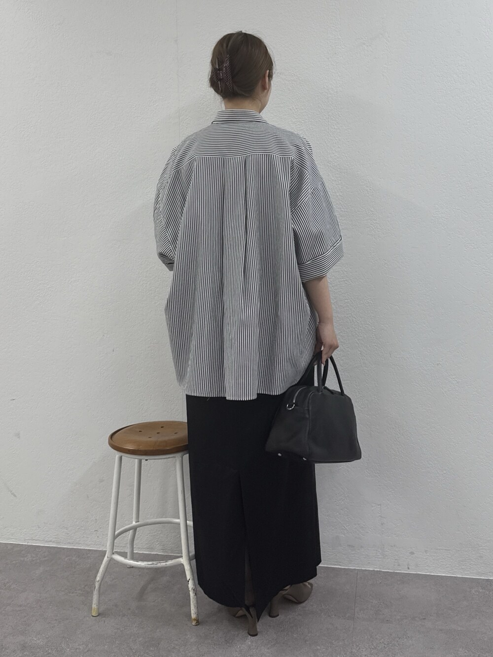 ブルー系のシャツ/ブラウス、ブラック系のボストンバッグ、ブラック系のスカートを着用したレディースの冬コーディネートの3枚目の写真