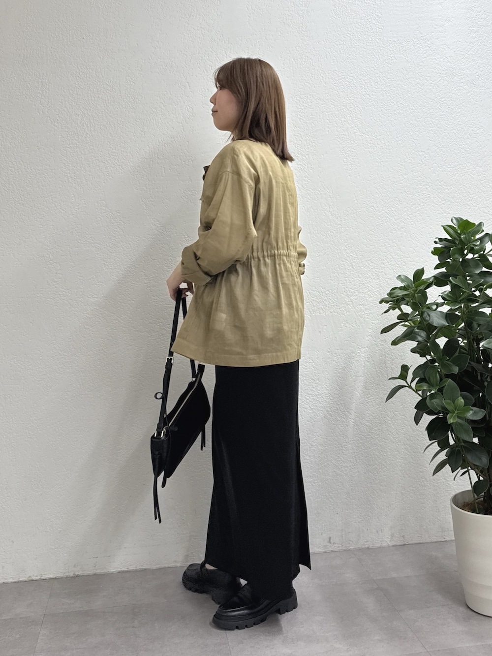 ブラック系のスカート、グリーン系のその他アウター、ホワイト系のTシャツ/カットソーを着用したレディースの冬コーディネートの2枚目の写真