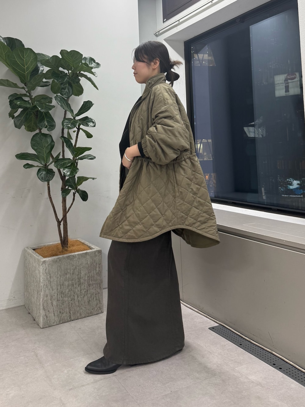グレー系のスカート、ブラック系のトートバッグ、グリーン系のその他アウターを着用したレディースの秋コーディネートの5枚目の写真