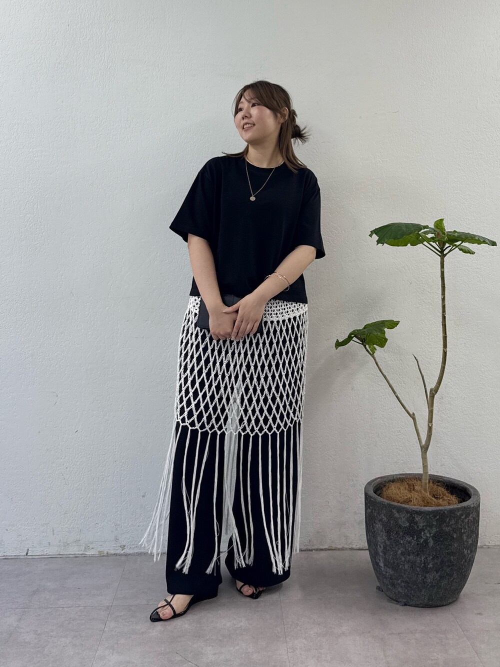 ブラック系のサンダル、ブラック系のその他パンツ、ホワイト系のスカートを着用したレディースの夏コーディネートの4枚目の写真