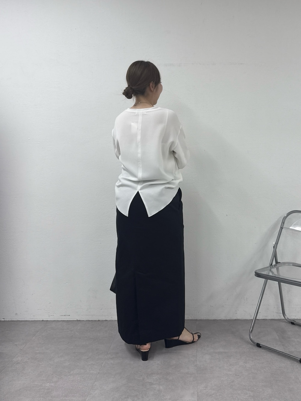 ブラック系のスカート、ホワイト系のシャツ/ブラウス、ゴールド系のネックレスを着用したレディースの春コーディネートの3枚目の写真