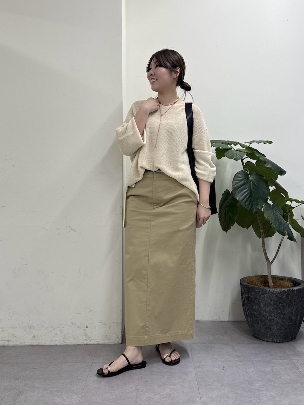 ベージュ系のスカート、ブラウン系のその他シューズ、ゴールド系のニット/セーターを着用したレディースの春コーディネートの4枚目の写真