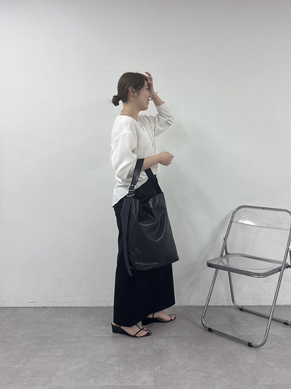 ブラック系のスカート、ホワイト系のシャツ/ブラウス、ゴールド系のネックレスを着用したレディースの春コーディネートの2枚目の写真