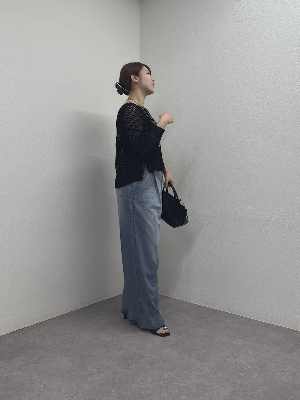 ブラック系のパーカー、ブルー系のその他パンツ、ブラック系のトートバッグを着用したレディースの春コーディネートの4枚目の写真