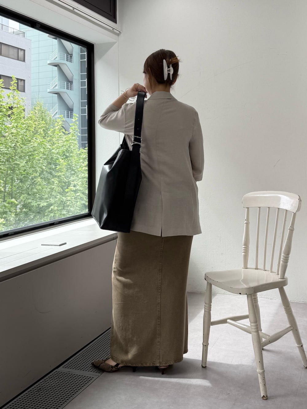 ブラウン系のパンプス、グリーン系のスカート、ホワイト系のキャミソールを着用したレディースの春コーディネートの3枚目の写真