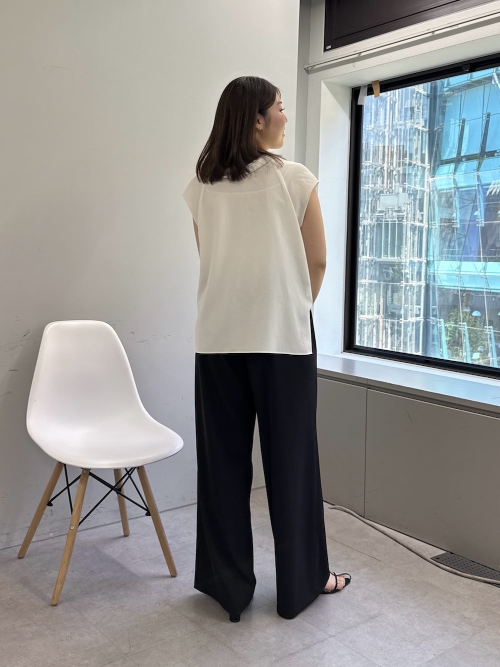 ブラック系のサンダル、ブラック系のその他パンツ、ホワイト系のシャツ/ブラウスを着用したレディースの春コーディネートの2枚目の写真