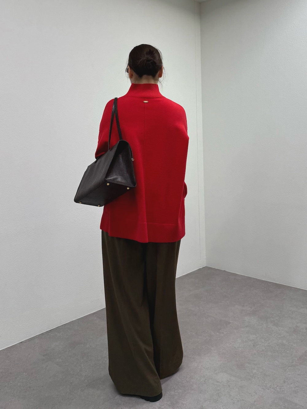 ブラウン系のその他パンツ、レッド系のニット/セーター、ブラック系のブーツを着用したレディースの秋コーディネートの2枚目の写真