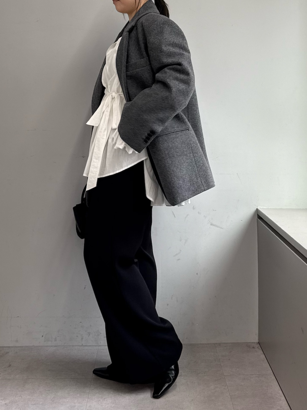 ブラック系のその他パンツ、ホワイト系のシャツ/ブラウス、グレー系のその他アウターを着用したレディースの秋コーディネートの2枚目の写真