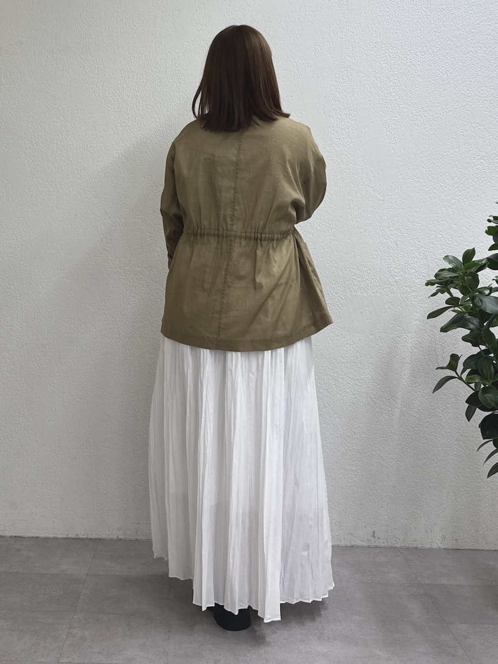 ホワイト系のスカート、グリーン系のその他アウター、ブラック系のショルダーバッグを着用したレディースの冬コーディネートの3枚目の写真