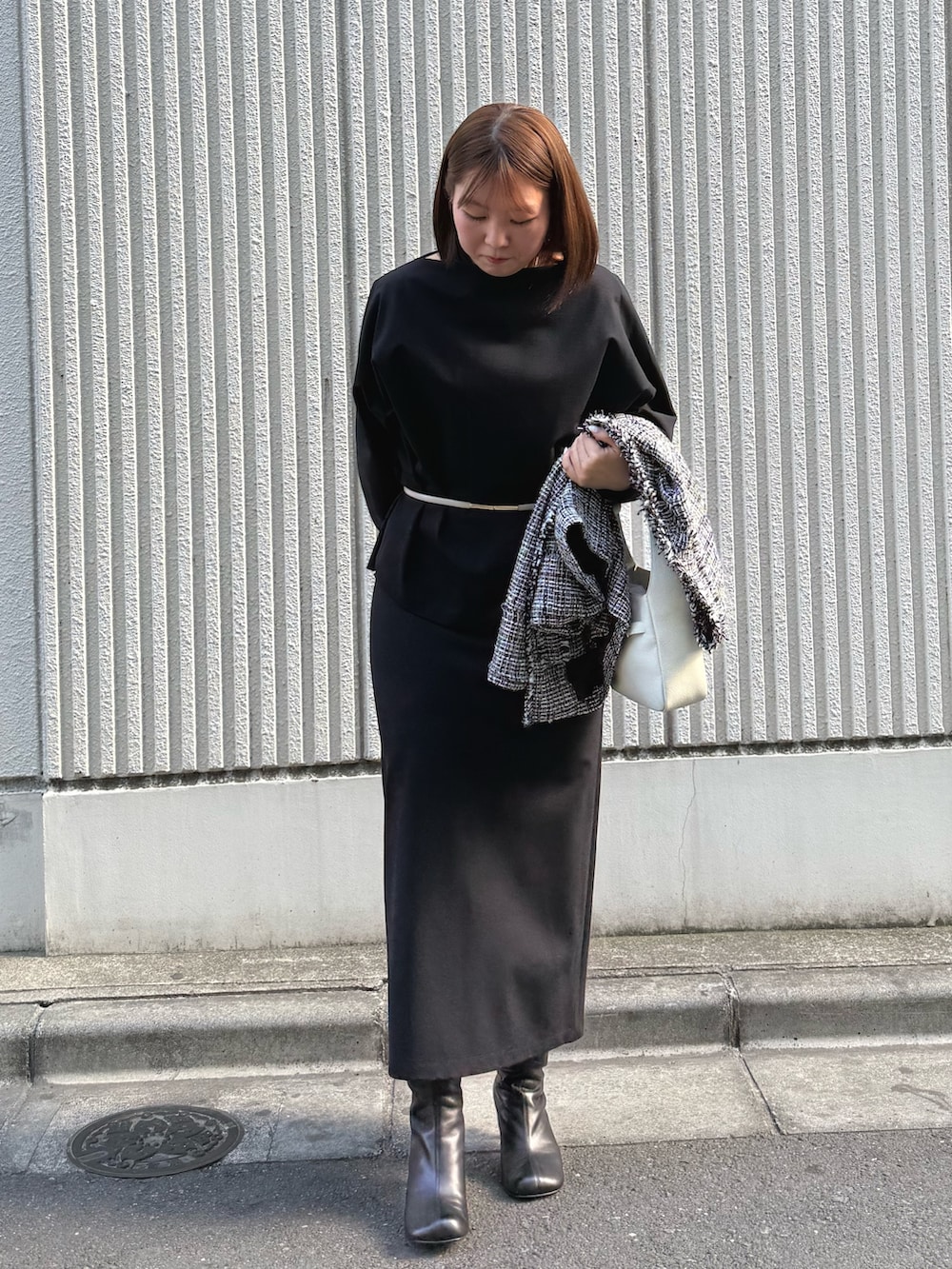 ブラック系のスカート、ブラック系のブーツ、ブラック系のTシャツ/カットソーを着用したレディースの冬コーディネートの2枚目の写真