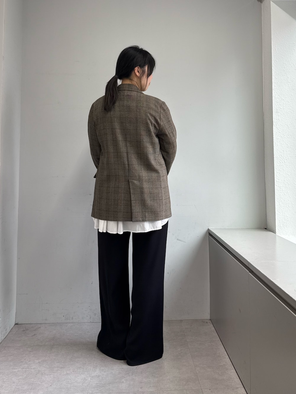 ブラック系のその他パンツ、ブラック系のトートバッグ、ブラウン系のベストを着用したレディースの秋コーディネートの3枚目の写真
