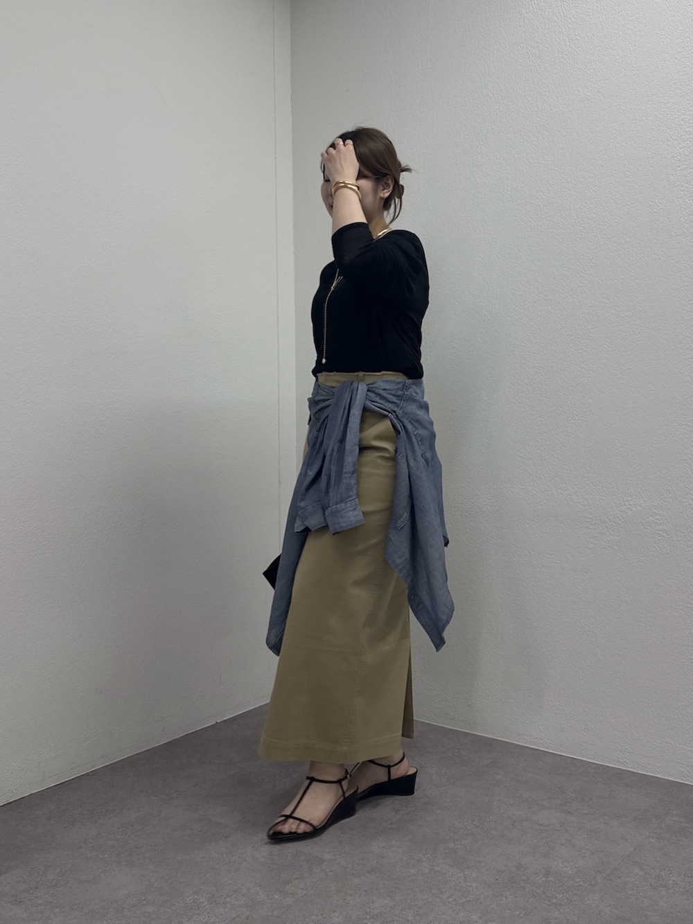 ブラック系のサンダル、ベージュ系のスカート、ブルー系のシャツ/ブラウスを着用したレディースの春コーディネートの2枚目の写真