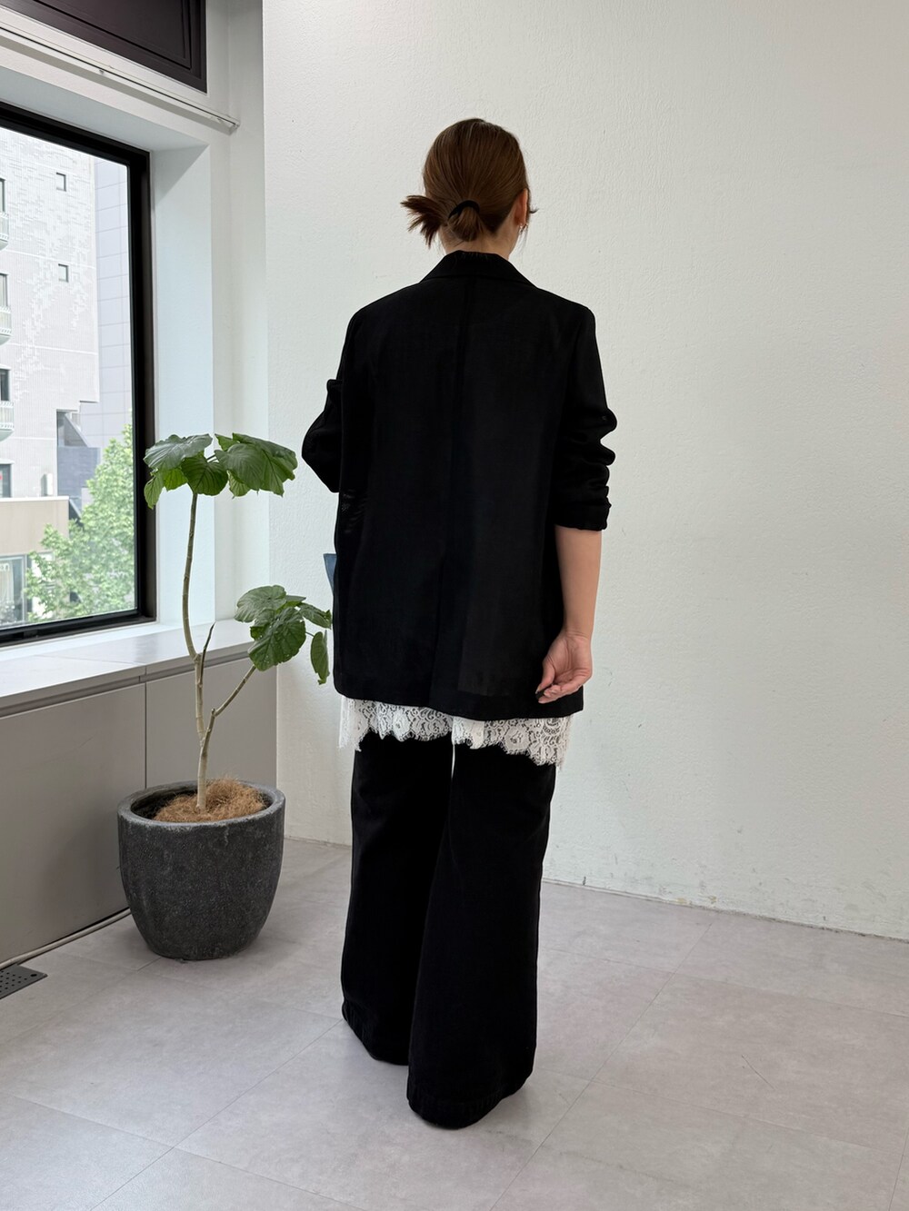 ブラック系のその他シューズ、ブラック系のデニムパンツ、ブルー系のハンドバッグを着用したレディースの春コーディネートの3枚目の写真