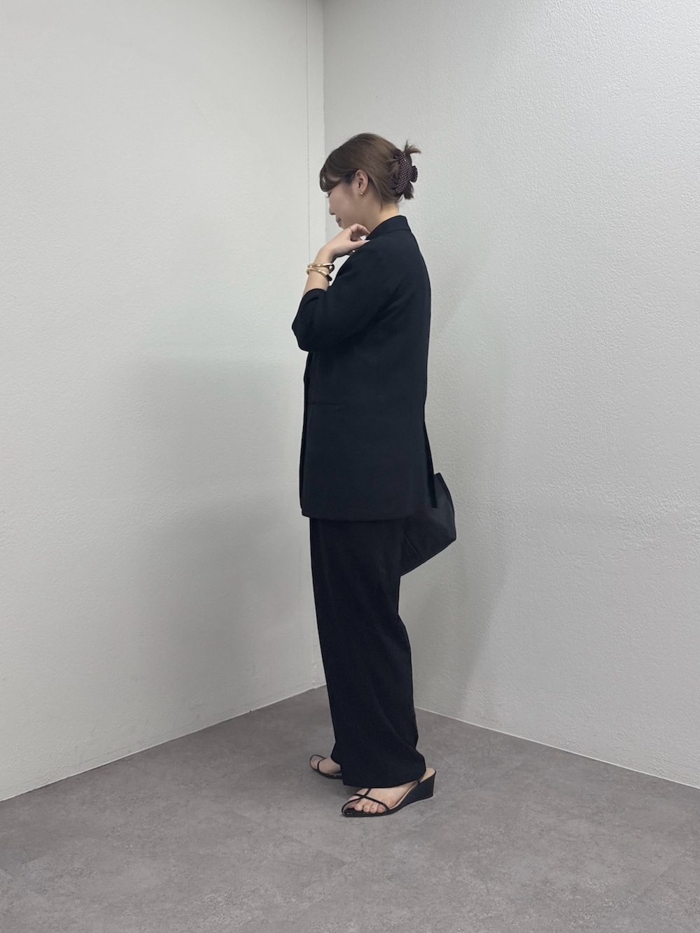 ブラック系のテーラードジャケット、ブラック系のトートバッグ、ホワイト系のシャツ/ブラウスを着用したレディースの春コーディネートの2枚目の写真