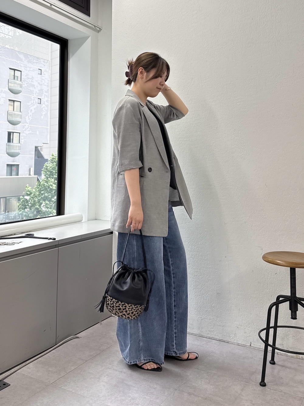 ブルー系のデニムパンツ、ブラック系のサンダル、ブラック系のキャミソールを着用したレディースの春コーディネートの2枚目の写真
