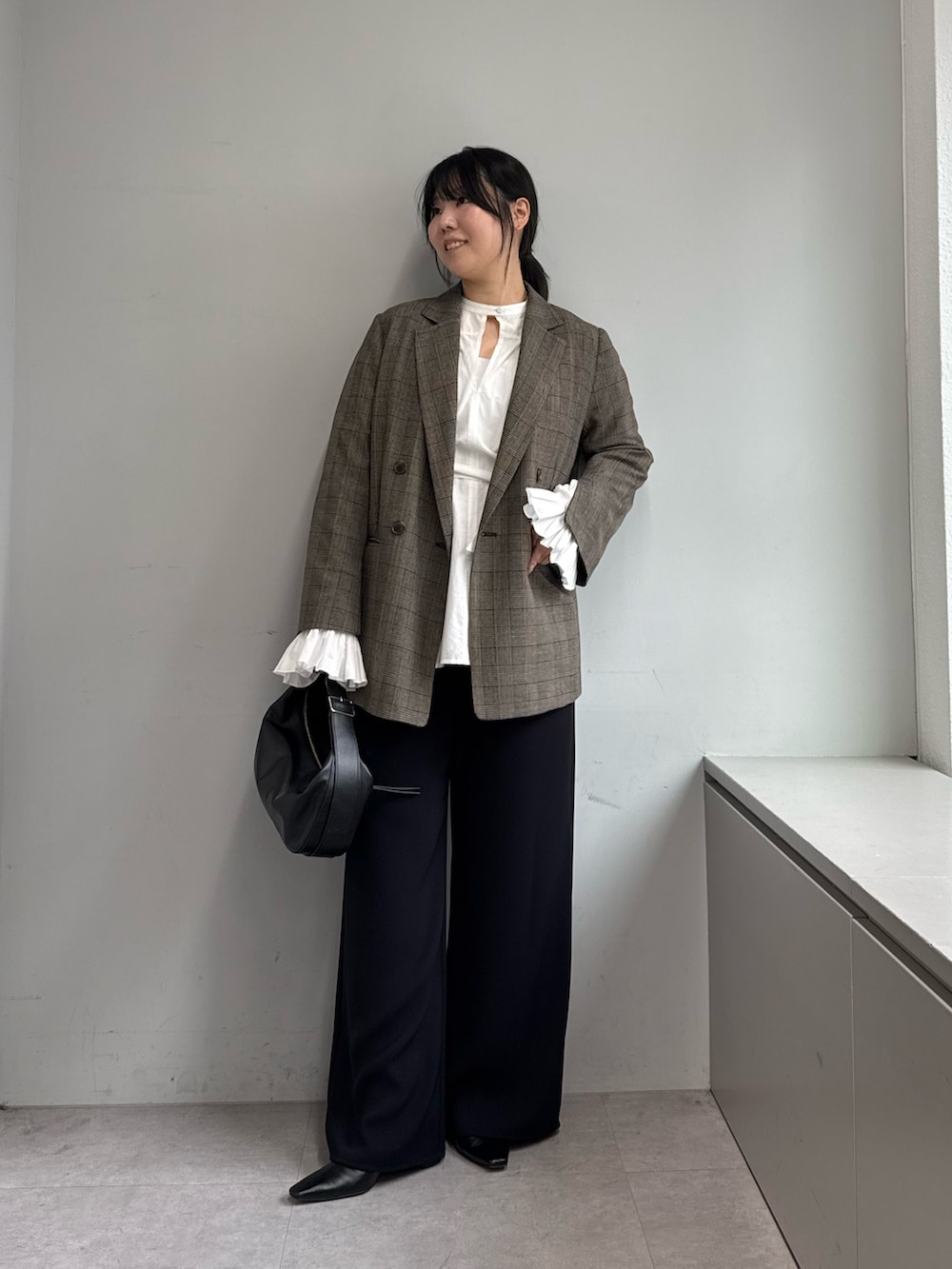 ブラック系のその他パンツ、ブラック系のトートバッグ、ブラウン系のベストを着用したレディースの秋コーディネートの4枚目の写真