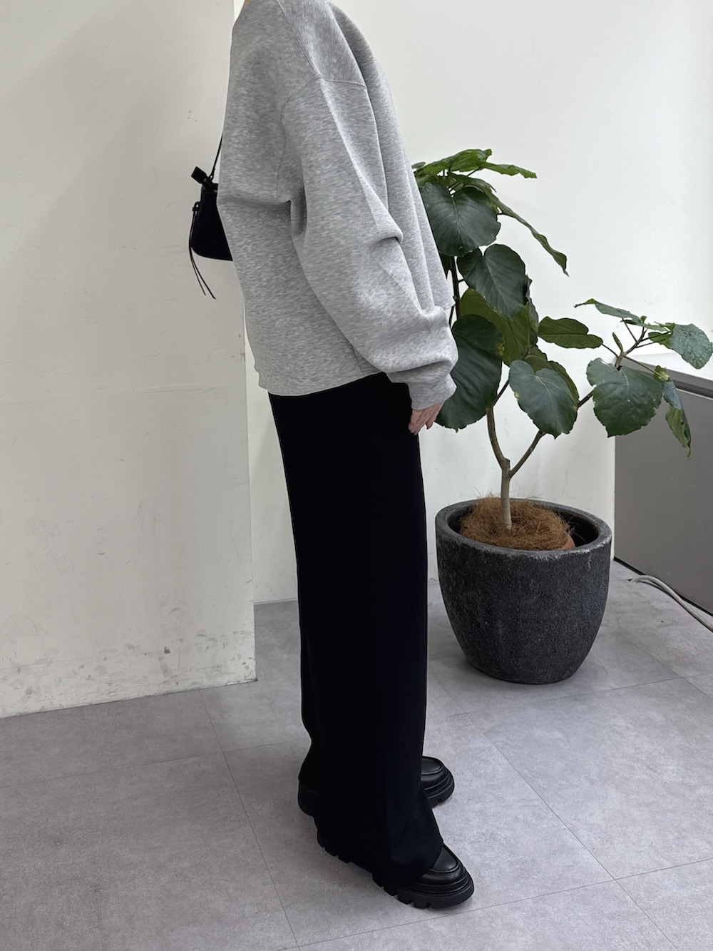 ブラック系のその他パンツ、ブラック系のローファー、ブラック系のショルダーバッグを着用したレディースの冬コーディネートの2枚目の写真