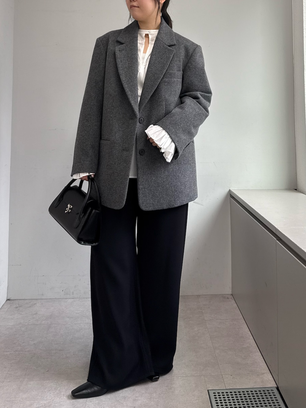ブラック系のその他パンツ、ホワイト系のシャツ/ブラウス、グレー系のその他アウターを着用したレディースの秋コーディネートの5枚目の写真