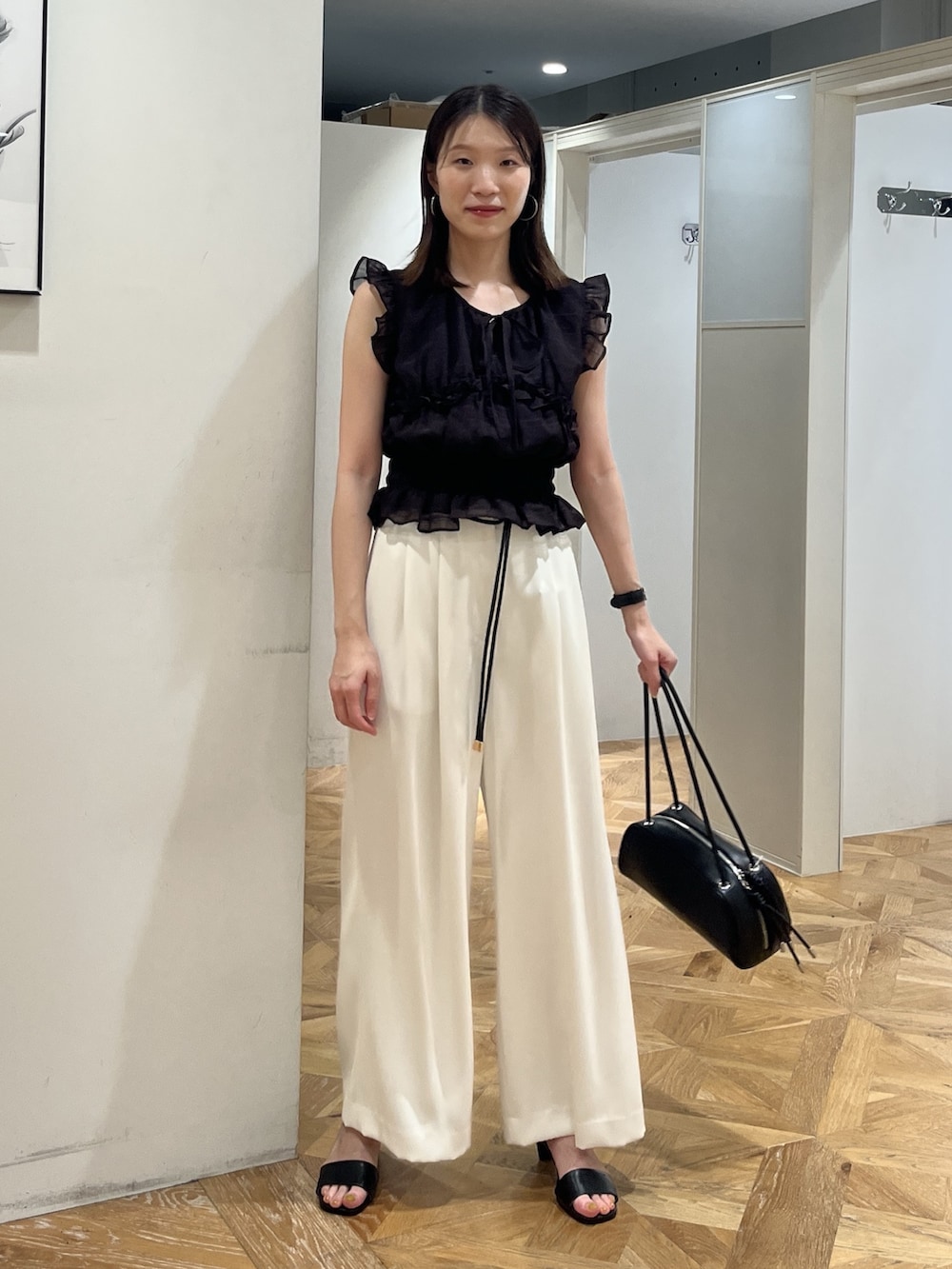 ブラック系のシャツ/ブラウス、ホワイト系のその他パンツ、ブラック系のボストンバッグを着用したレディースの夏コーディネートの2枚目の写真