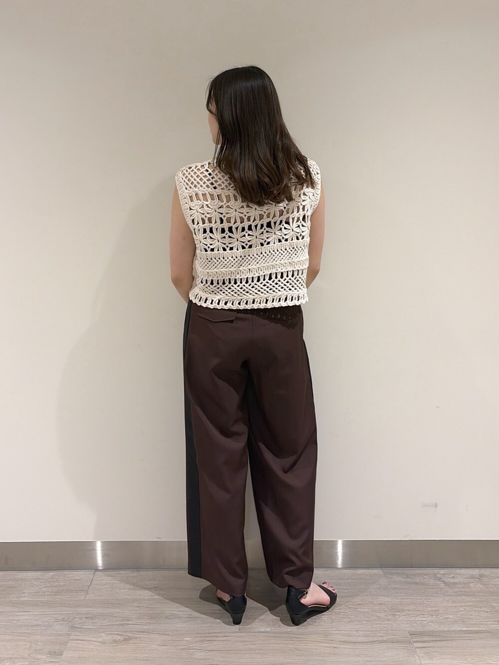 ホワイト系のベスト、ブラウン系のその他パンツ、ブラック系のサンダルを着用したレディースの夏コーディネートの6枚目の写真