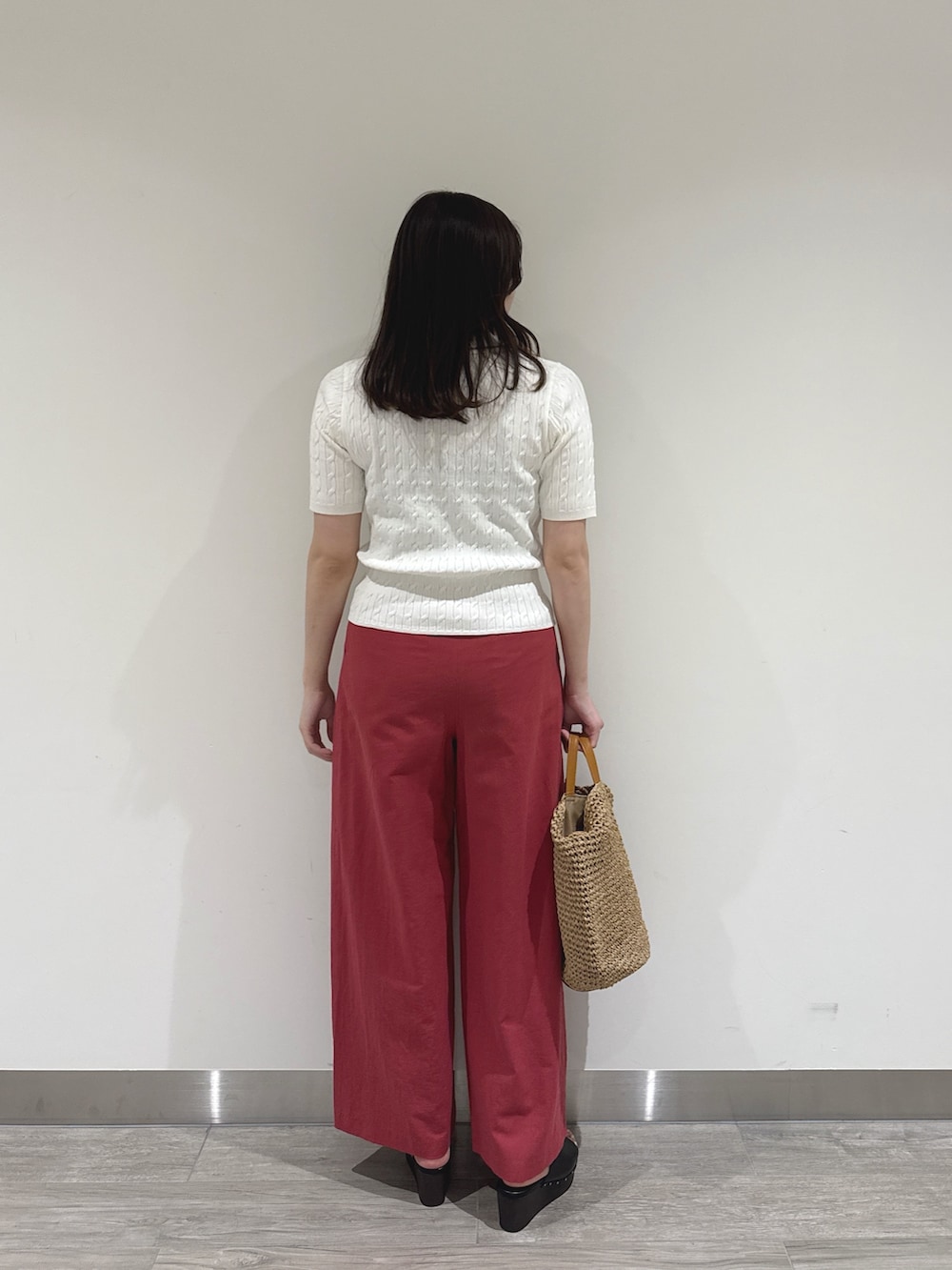 ブラック系のサンダル、ホワイト系のポロシャツ、レッド系のその他パンツを着用したレディースの夏コーディネートの3枚目の写真