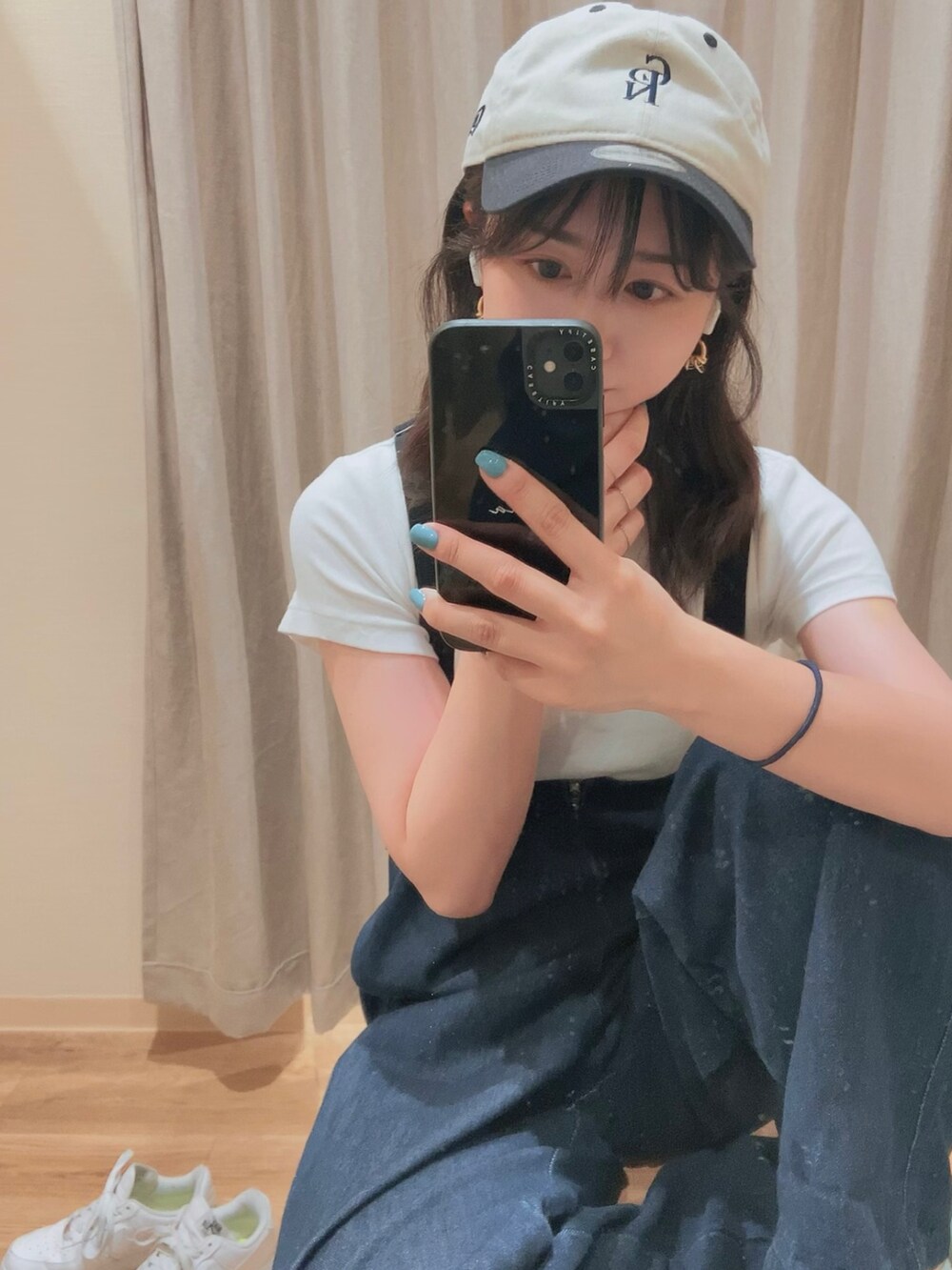 ブルー系のサロペット/オーバーオール、ホワイト系のスニーカー、ブルー系のキャップを着用したレディースの夏コーディネートの2枚目の写真