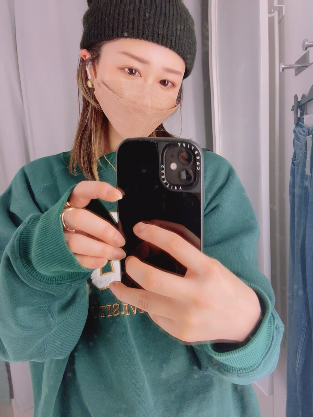 ブラック系のワンピース、グリーン系のスウェット、ホワイト系のスニーカーを着用したレディースの春コーディネートの2枚目の写真