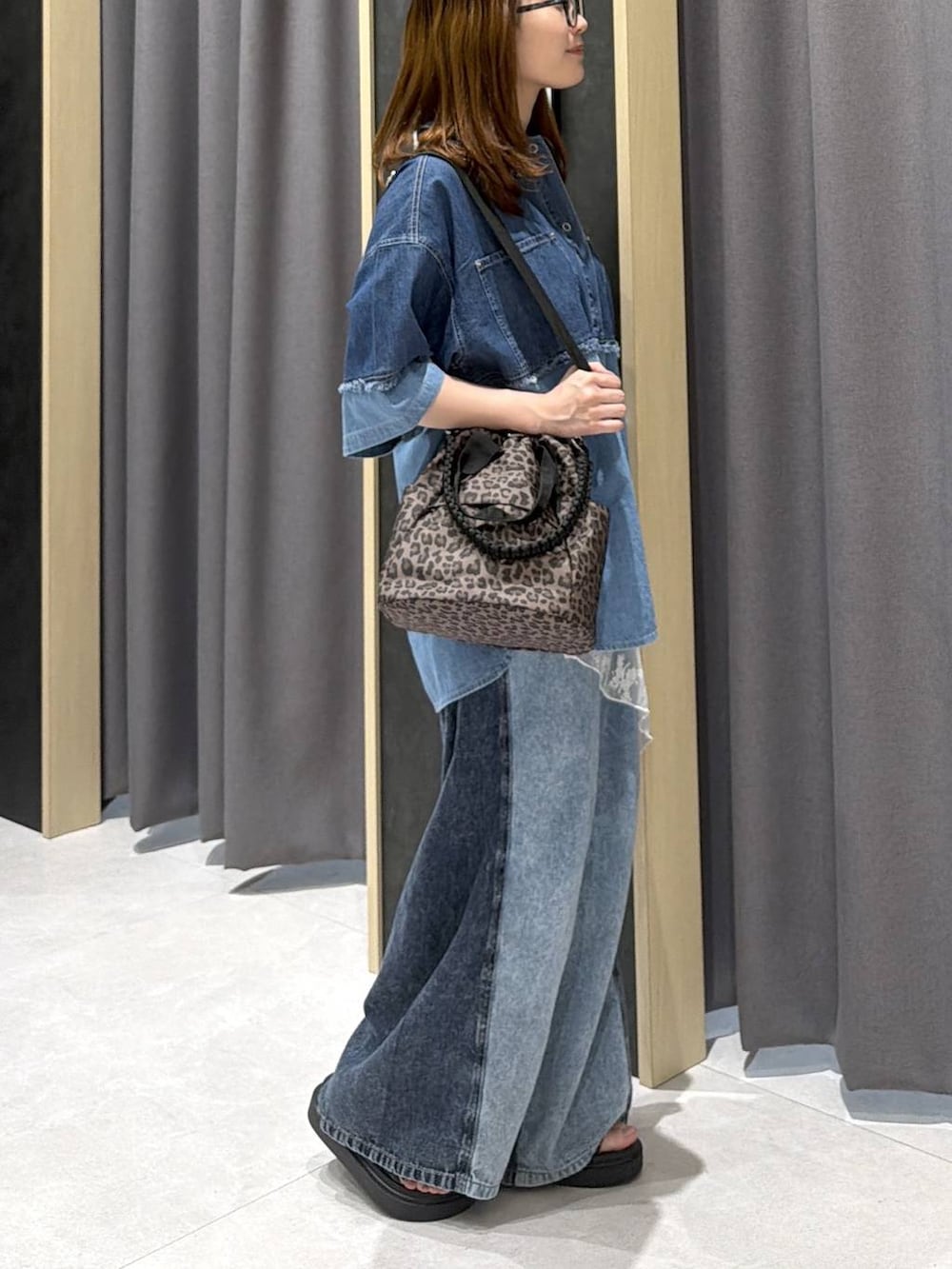 ブルー系のデニムパンツ、その他のショルダーバッグ、その他のサンダルを着用したレディースの春コーディネートの2枚目の写真