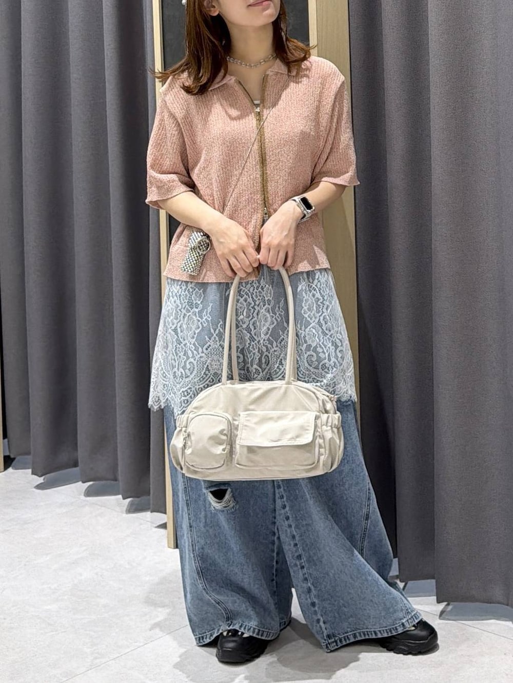 ブルー系のデニムパンツ、ホワイト系のボストンバッグ、ホワイト系のキャミソールを着用したレディースの春コーディネートの2枚目の写真
