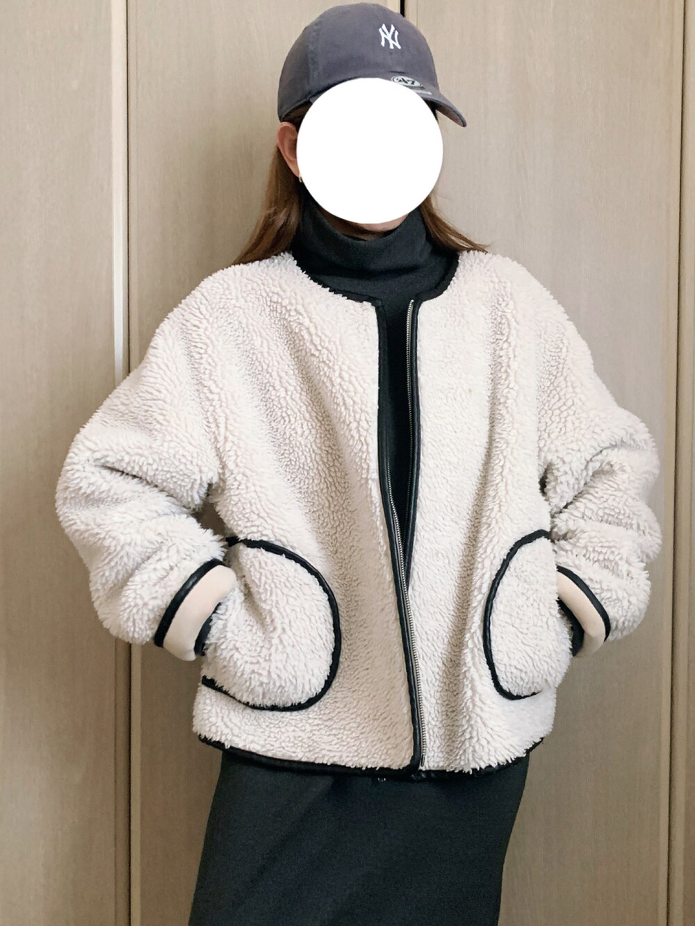 ホワイト系のブルゾン、グレー系のワンピースを着用したレディースの冬コーディネートの2枚目の写真