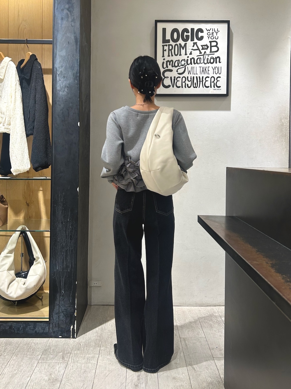 グレー系のTシャツ/カットソー、ブラック系のデニムパンツ、ブラック系のローファーを着用したレディースの秋コーディネートの3枚目の写真