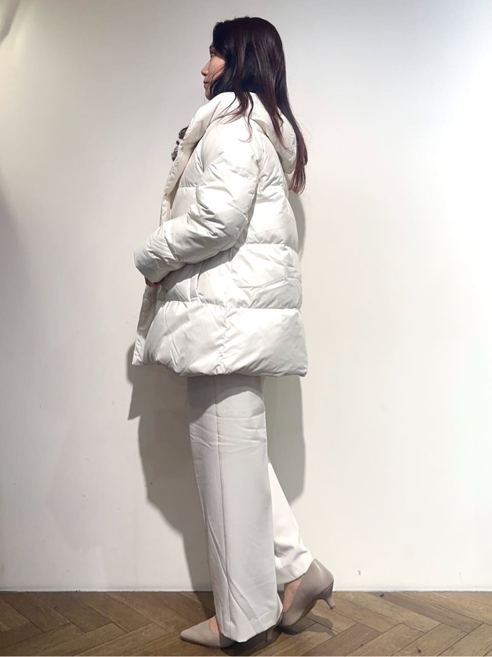ホワイト系のダウンジャケット/コート、イエロー系のニット/セーター、ホワイト系のTシャツ/カットソーを着用したレディースの冬コーディネートの3枚目の写真
