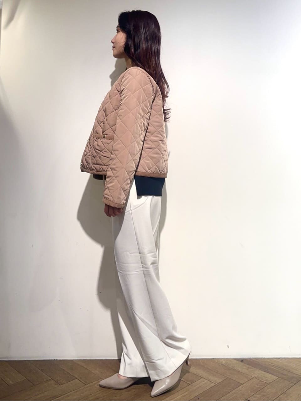 イエロー系のノーカラージャケット、ブラック系のニット/セーター、ホワイト系のその他パンツを着用したレディースの秋コーディネートの3枚目の写真