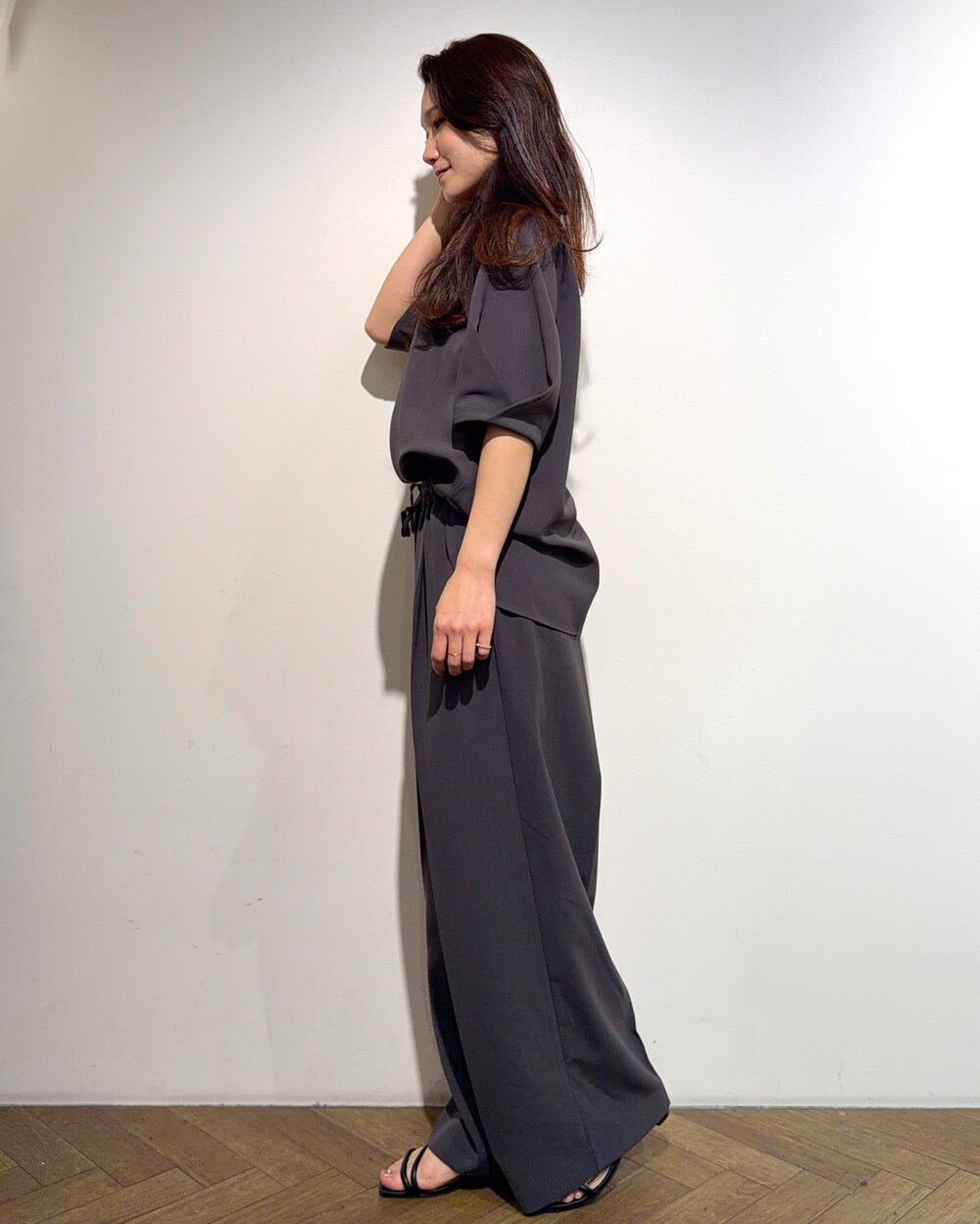 グレー系のシャツ/ブラウス、グレー系のその他パンツ、ブラック系のサンダルを着用したレディースの春コーディネートの2枚目の写真