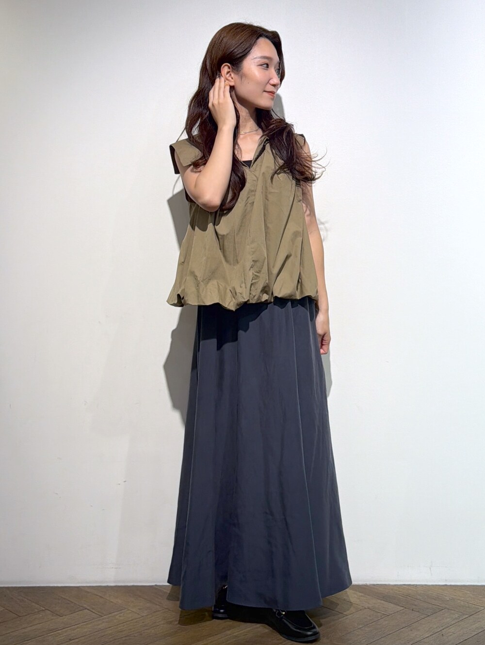 ブラウン系のシャツ/ブラウス、グレー系のスカート、ブラック系のトートバッグを着用したレディースの夏コーディネートの8枚目の写真