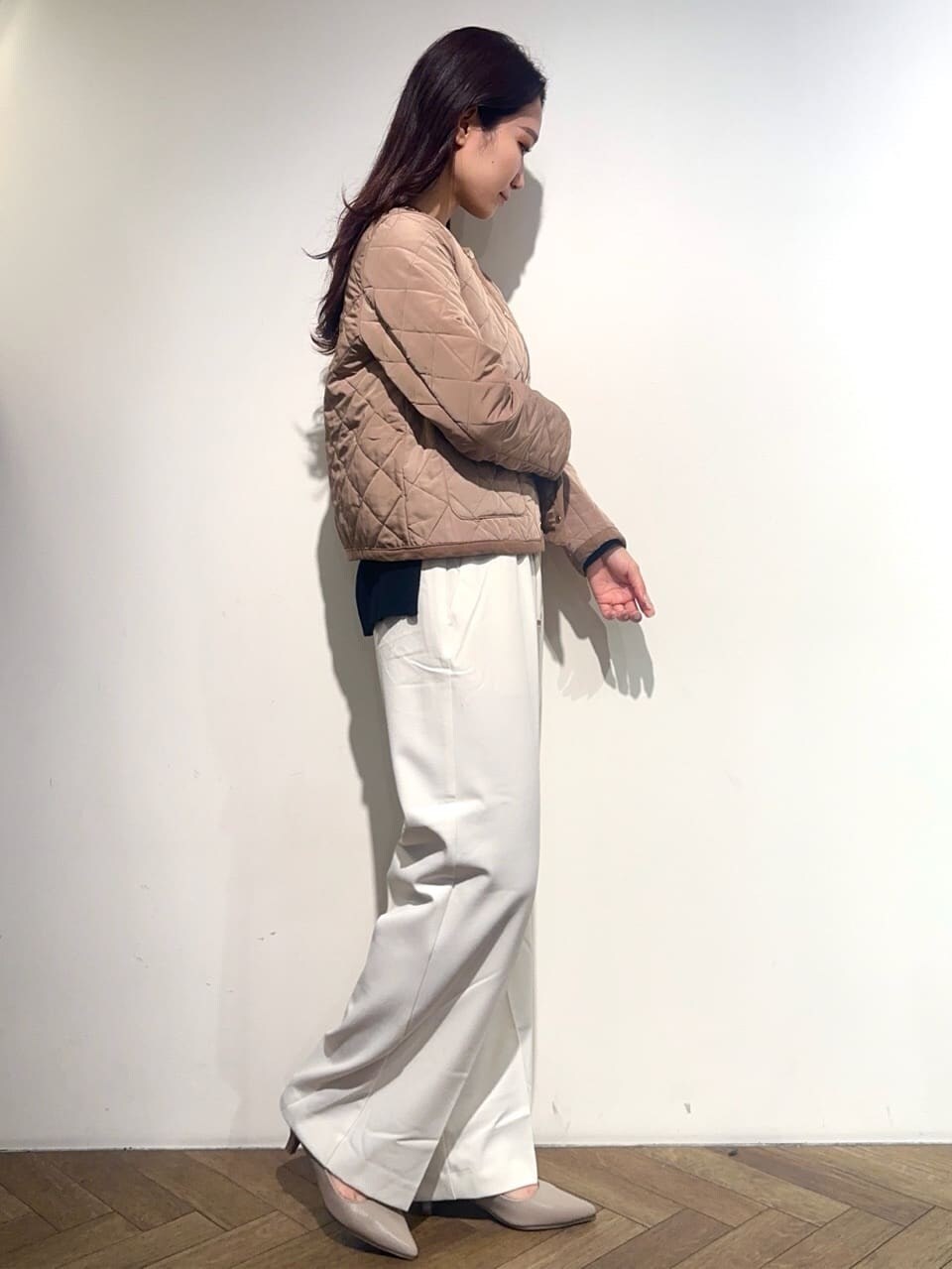イエロー系のノーカラージャケット、ブラック系のニット/セーター、ホワイト系のその他パンツを着用したレディースの秋コーディネートの5枚目の写真