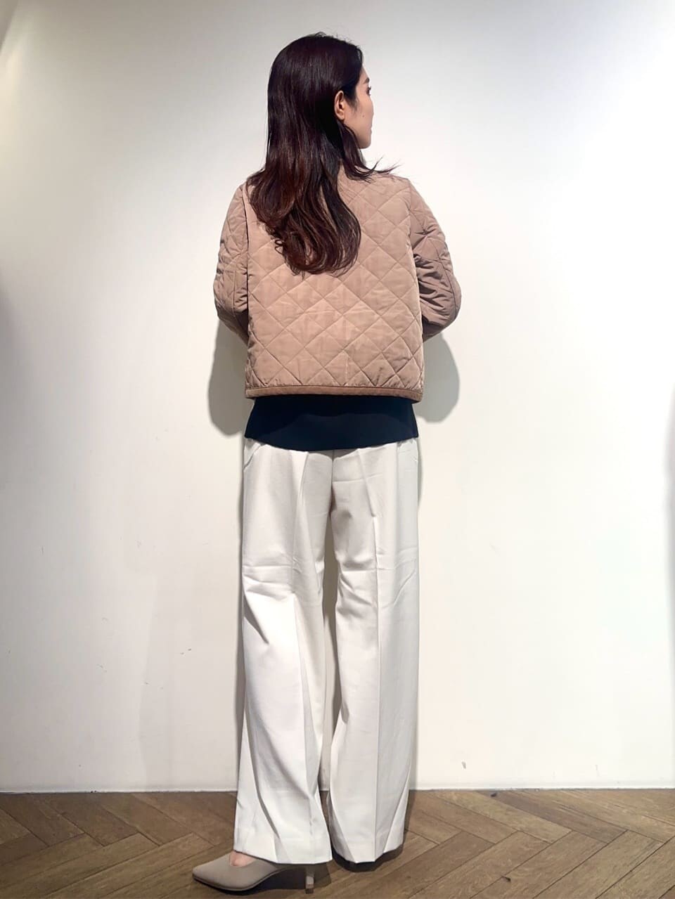 イエロー系のノーカラージャケット、ブラック系のニット/セーター、ホワイト系のその他パンツを着用したレディースの秋コーディネートの4枚目の写真