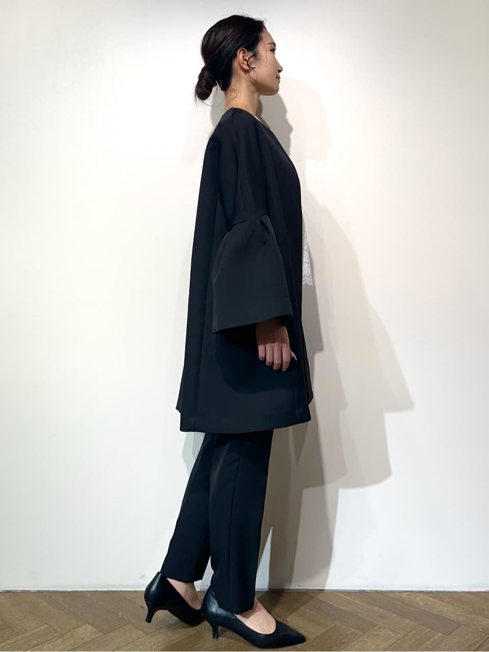 ブルー系のノーカラーコート、ホワイト系のシャツ/ブラウス、ブラック系のその他パンツを着用したレディースの冬コーディネートの5枚目の写真