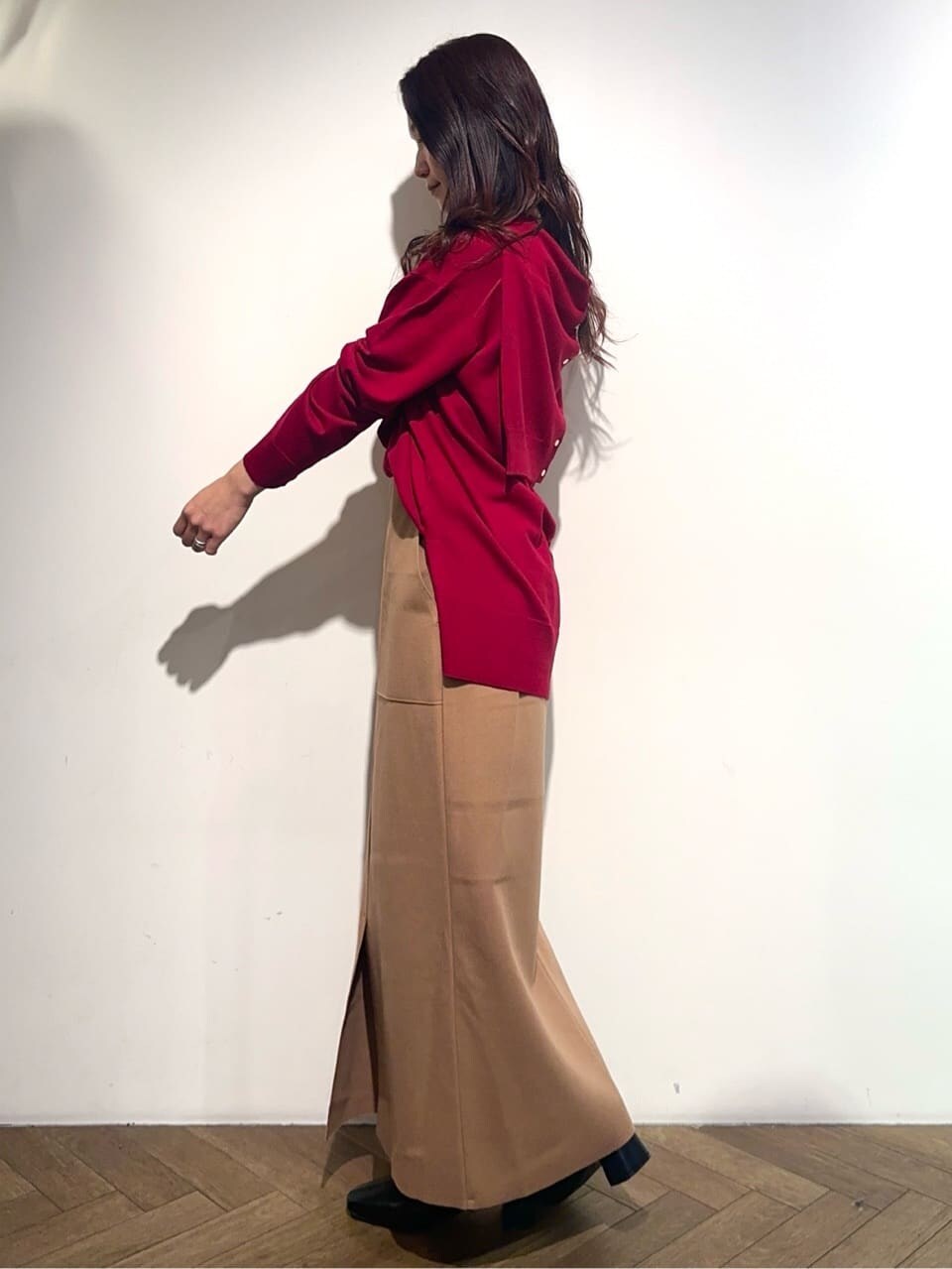 レッド系のニット/セーター、レッド系のカーディガン/ボレロ、イエロー系のスカートを着用したレディースの冬コーディネートの4枚目の写真