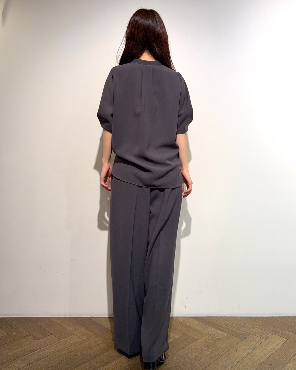 グレー系のシャツ/ブラウス、グレー系のその他パンツ、ブラック系のサンダルを着用したレディースの春コーディネートの3枚目の写真