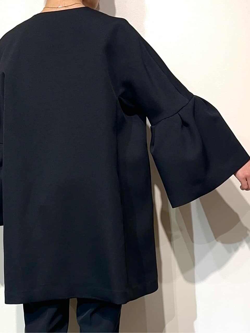 ブルー系のノーカラーコート、ホワイト系のシャツ/ブラウス、ブラック系のその他パンツを着用したレディースの冬コーディネートの4枚目の写真