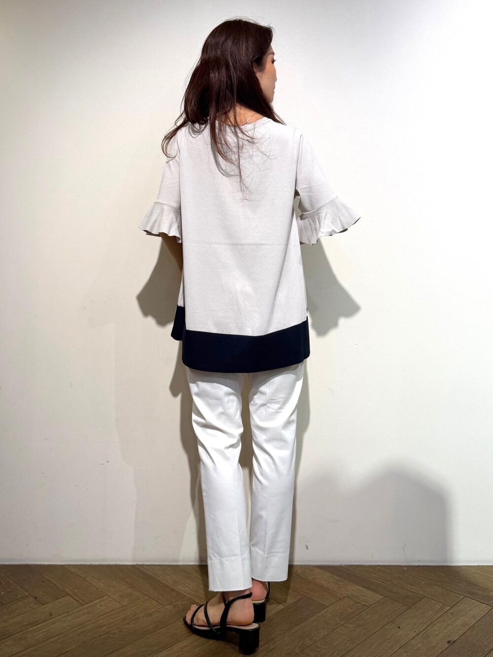 ベージュ系のニット/セーター、ホワイト系のその他パンツ、ブラック系のトートバッグを着用したレディースの春コーディネートの5枚目の写真