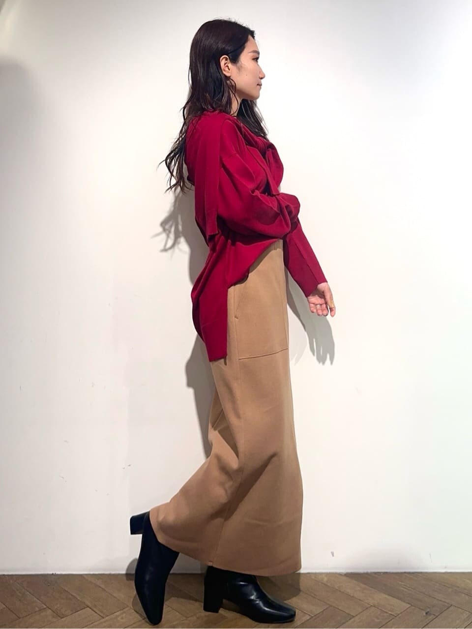 レッド系のニット/セーター、レッド系のカーディガン/ボレロ、イエロー系のスカートを着用したレディースの冬コーディネートの6枚目の写真