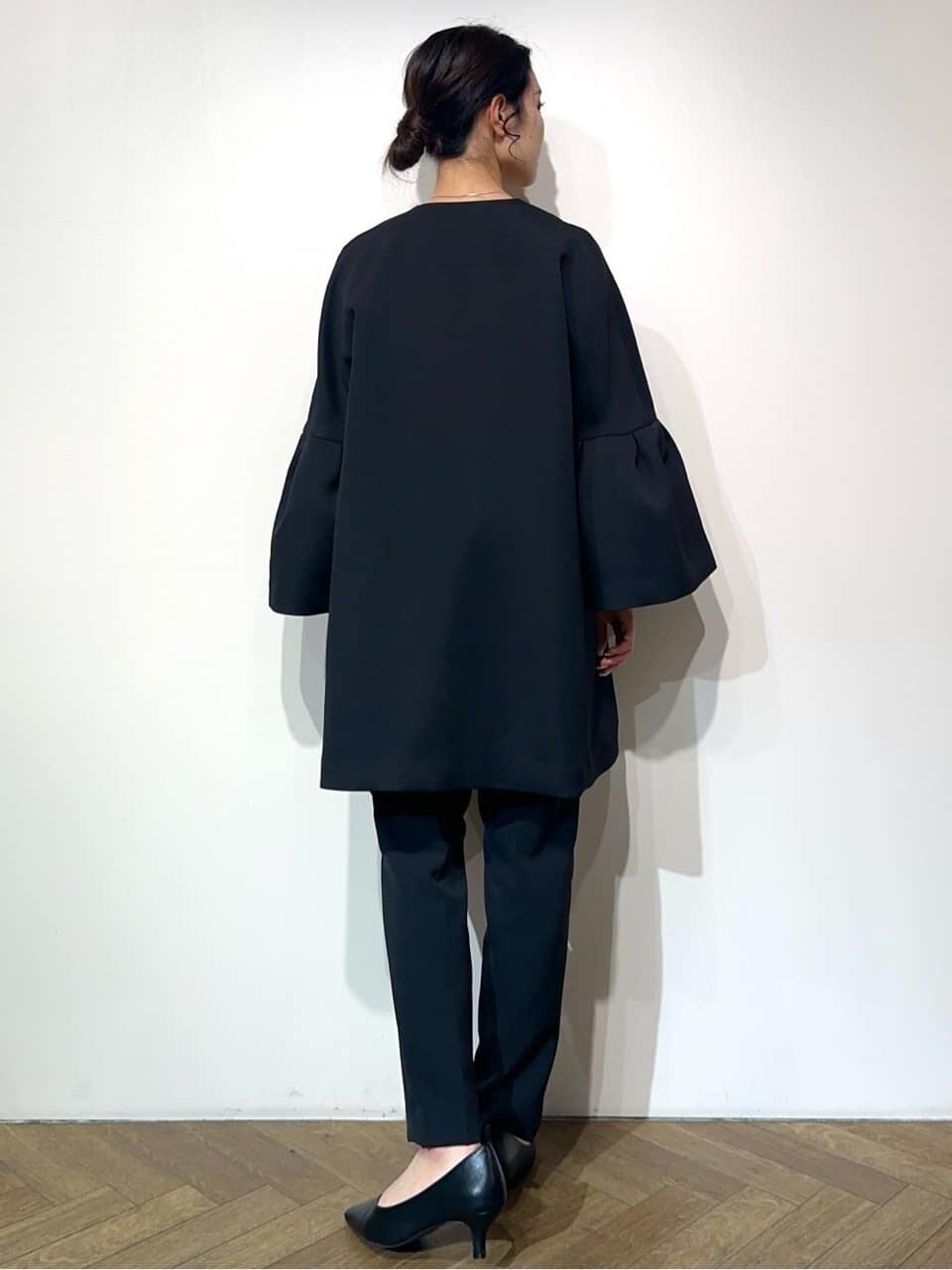 ブルー系のノーカラーコート、ホワイト系のシャツ/ブラウス、ブラック系のその他パンツを着用したレディースの冬コーディネートの3枚目の写真