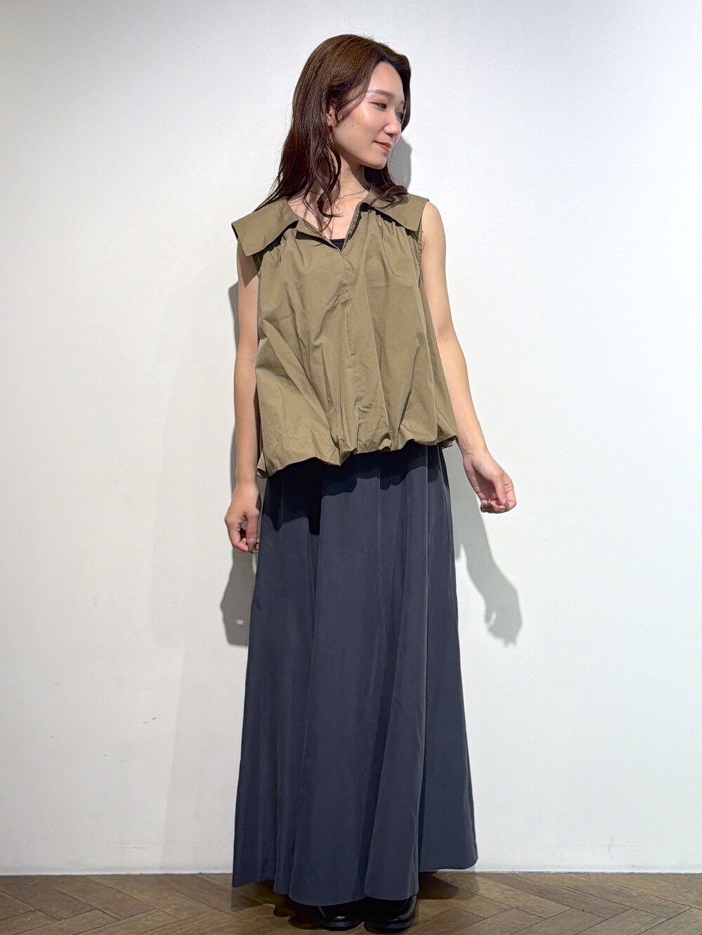ブラウン系のシャツ/ブラウス、グレー系のスカート、ブラック系のトートバッグを着用したレディースの夏コーディネートの9枚目の写真