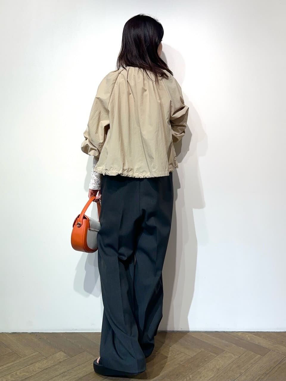 ベージュ系のノーカラーコート、ホワイト系のTシャツ/カットソー、グレー系のサロペット/オーバーオールを着用したレディースの春コーディネートの4枚目の写真