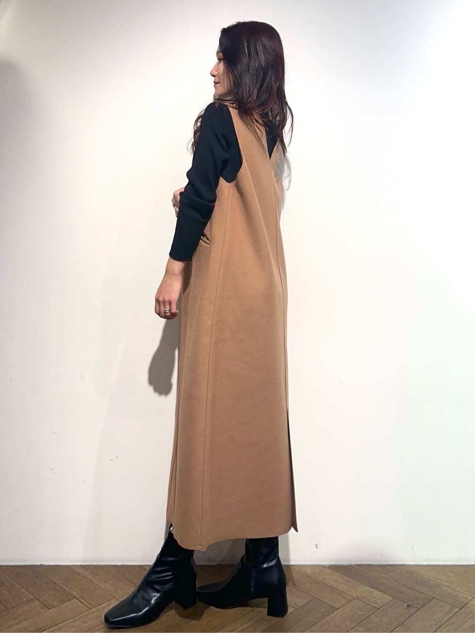 ブラック系のニット/セーター、イエロー系のワンピース、ホワイト系のハンドバッグを着用したレディースの冬コーディネートの3枚目の写真