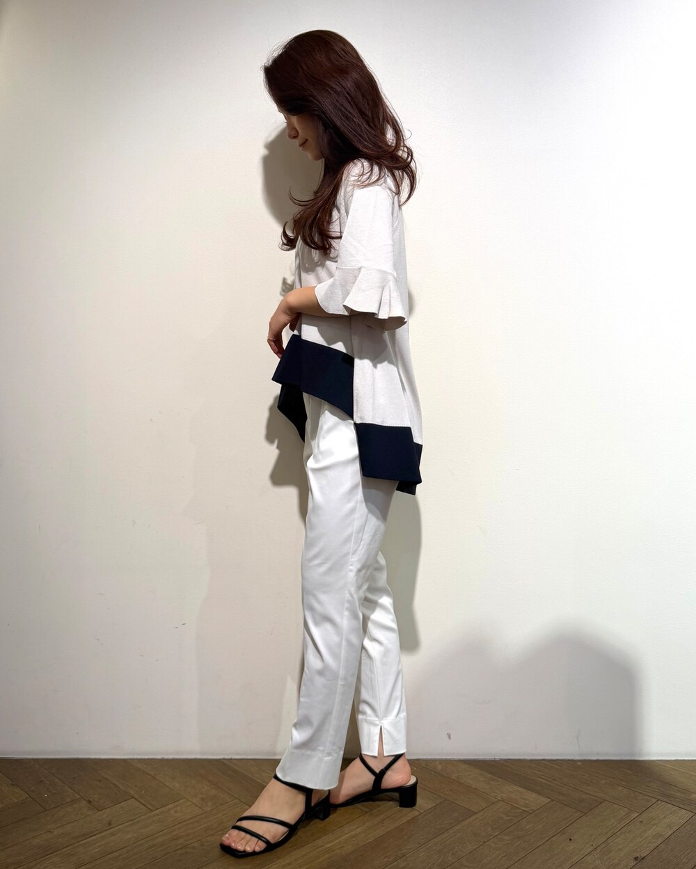 ベージュ系のニット/セーター、ホワイト系のその他パンツ、ブラック系のトートバッグを着用したレディースの春コーディネートの4枚目の写真